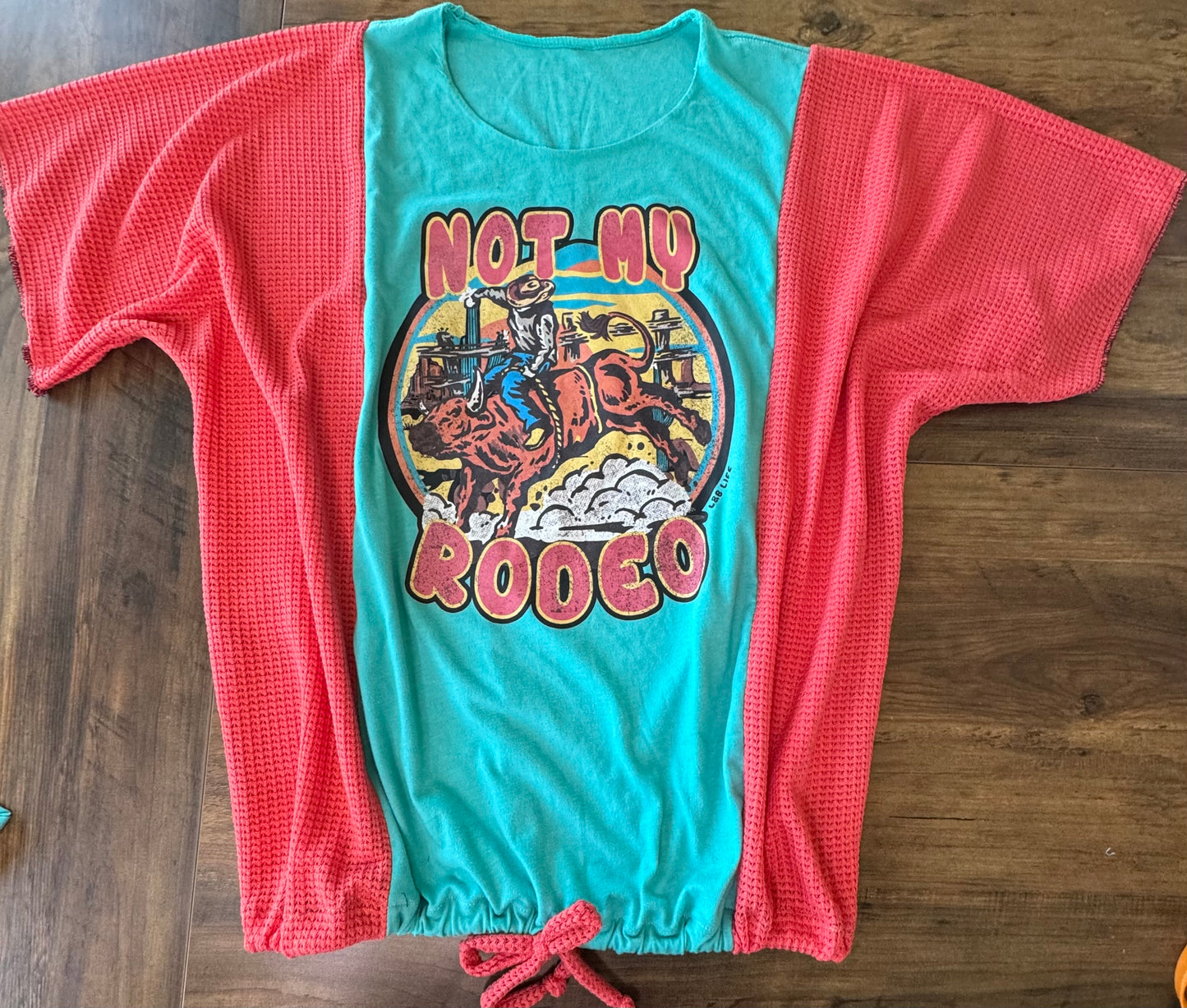 "Not my Rodeo" Teal T-Shirt with Coral accents. One Size Fits Most.